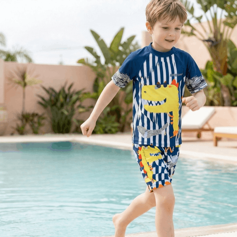 Bright boys' swimwear featuring a cartoon dinosaur design with UV protection from NOVA, suitable for kids' beach and pool fun.