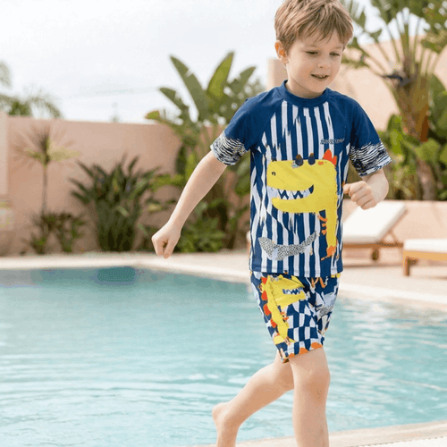 Bright boys' swimwear featuring a cartoon dinosaur design with UV protection from NOVA, suitable for kids' beach and pool fun.