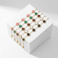 A set of gold floral statement bracelets displayed on a white geometric block against a light gray background, with promotional text above and below.