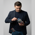 Man in a dark suit holding a cardholder with multiple cards on a plain background
