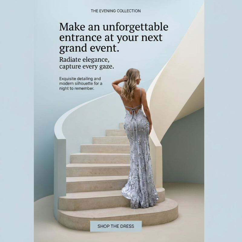A woman stands on a curved staircase wearing a sleeveless, backless silver-gray evening gown with a tie at the back. The scene is set in a clean architectural interior with pale blue and beige tones, with promotional text reading 'THE EVENING COLLECTION' and 'Make an unforgettable entrance at your next grand event.