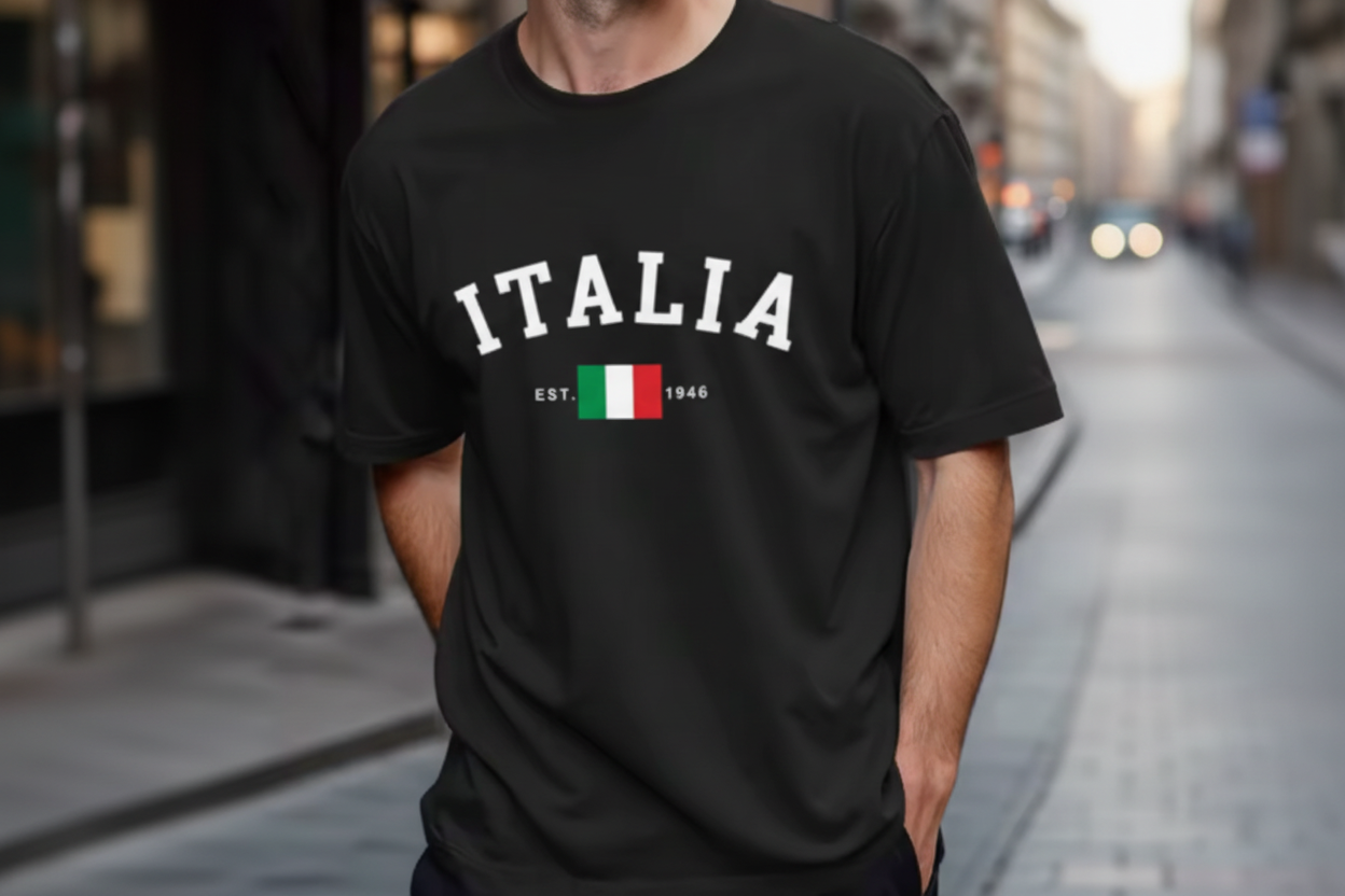 A man wearing a black short-sleeve t-shirt with 'ITALIA' printed in white across the chest, a small Italian flag graphic, and 'EST. 1946' underneath.