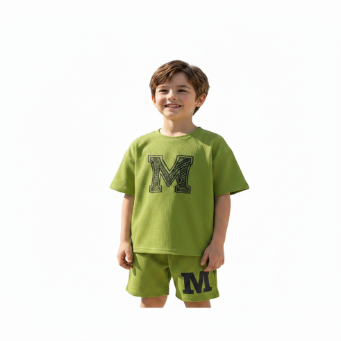 Child wearing a green outfit with a large 'M' on a white background