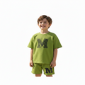 Child wearing a green outfit with a large 'M' on a white background