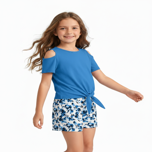 Young girl wearing a blue top and floral shorts on a white background
